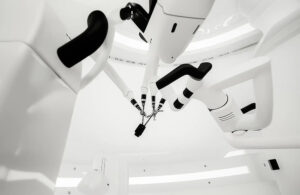 Three surgical robot arms in an operating room.